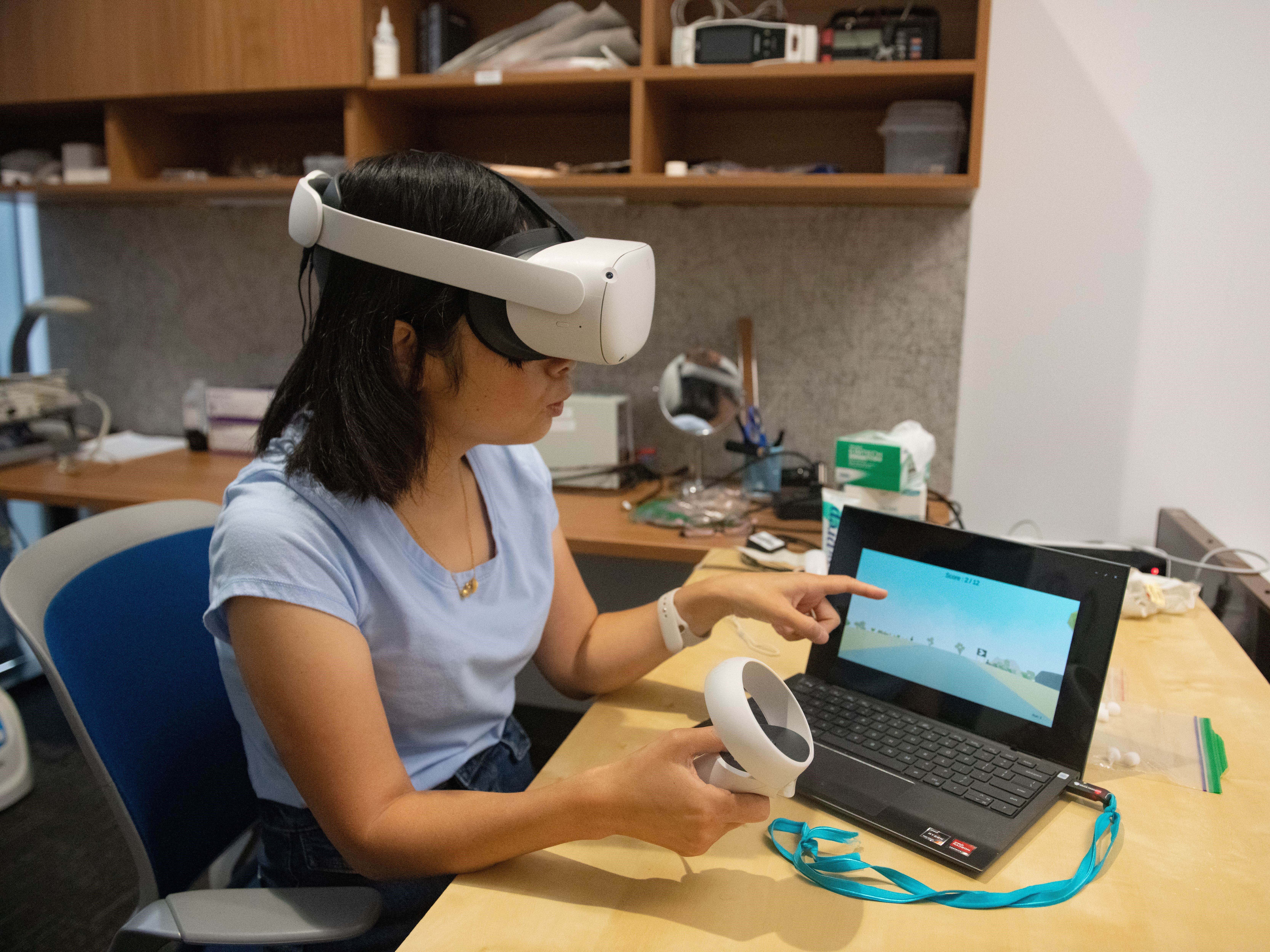 Hongbian Li wearing Meta Oculus headset and holding remote