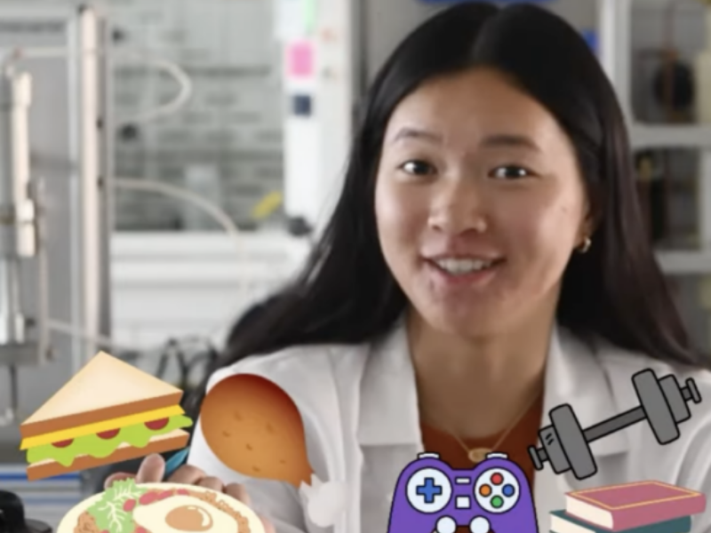 Texas Engineering student in lab coat with cartoon graphics in front of her