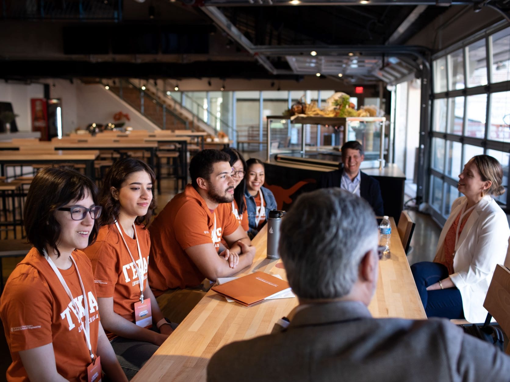 Group of UT Austin Tx engineering students sitting with Michael and Erika Linford