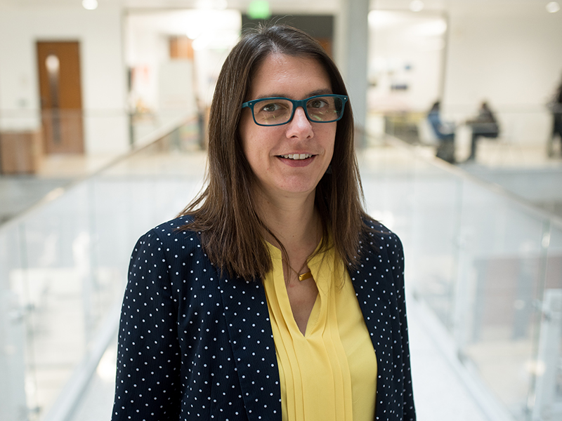 Christine Julien on the pedestrian bridge inside of the Engineering Education and Research Center.