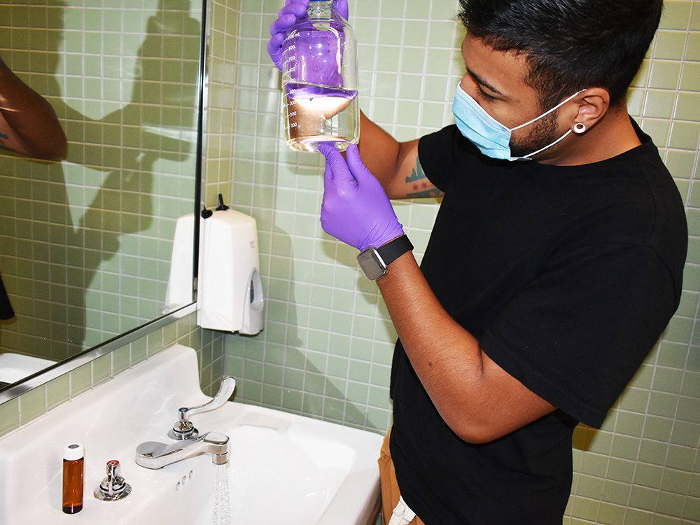 person wearing mask cleaning bathroom