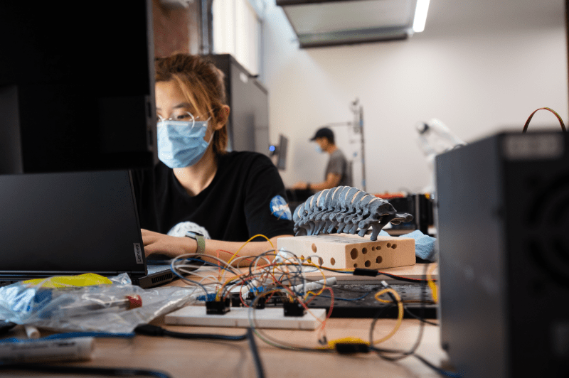 Texas engineering student wearing medical mask working on machine