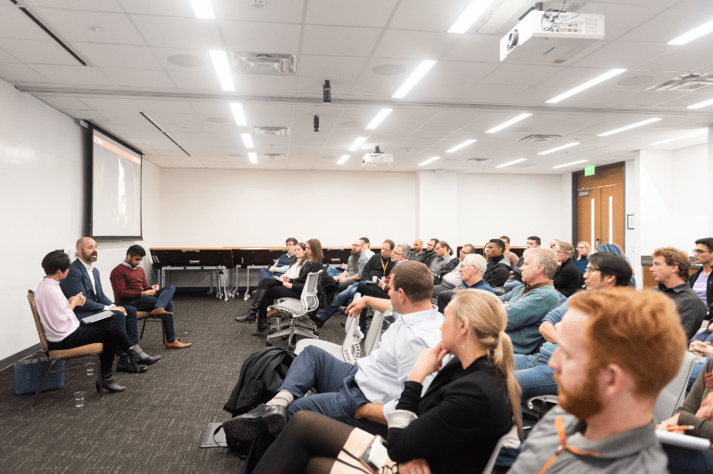 Several people seated in a conference room during presentation