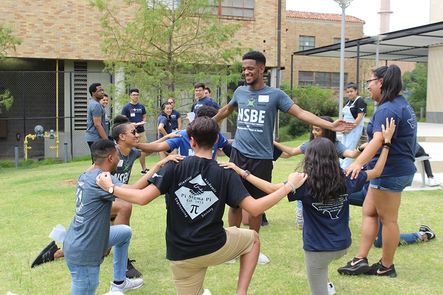 Students gather in a circle to participate in an activity on the EER lawn.