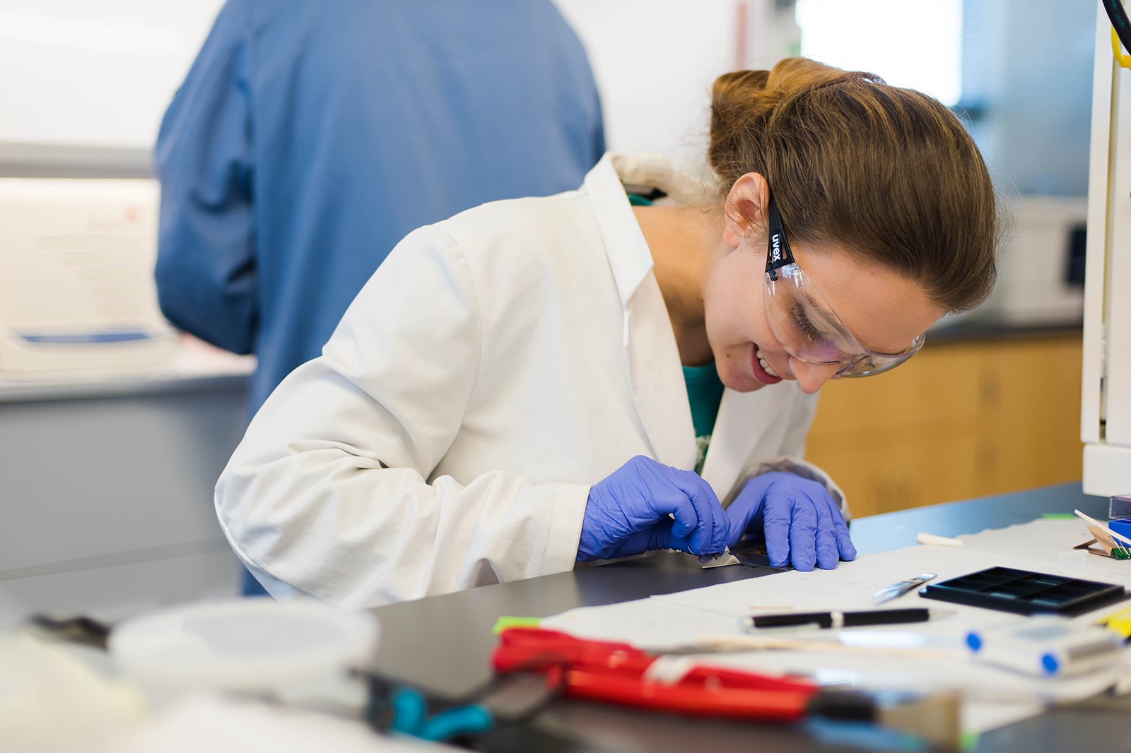 Texas chemical engineering student in lab safety gear working at a lab table