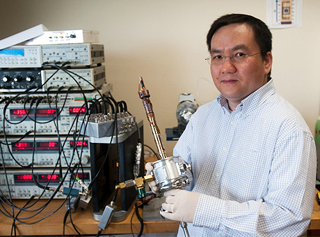 Texas Engineer Li Shi sitting with nanoelectronic graphene test equipment