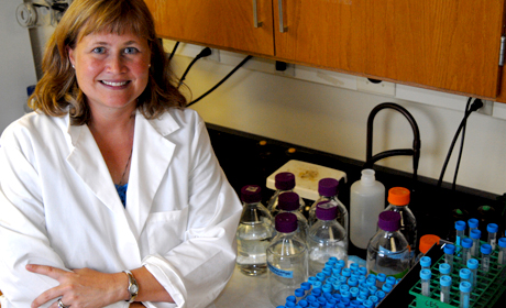 Texas Engineer Christine Schmidt sitting at desk in lab coat