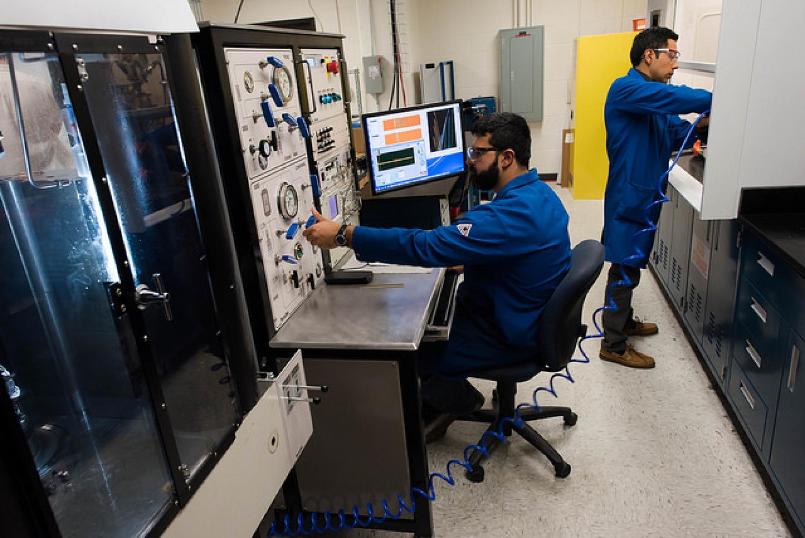 Texas engineers wearing jumpsuits and working in a lab