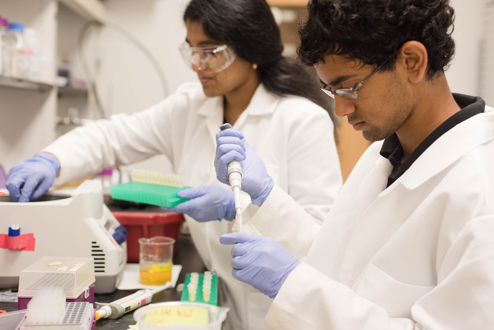 Texas Engineering chemical engineering students in lab coats working with chemicals in test tubes and beakers