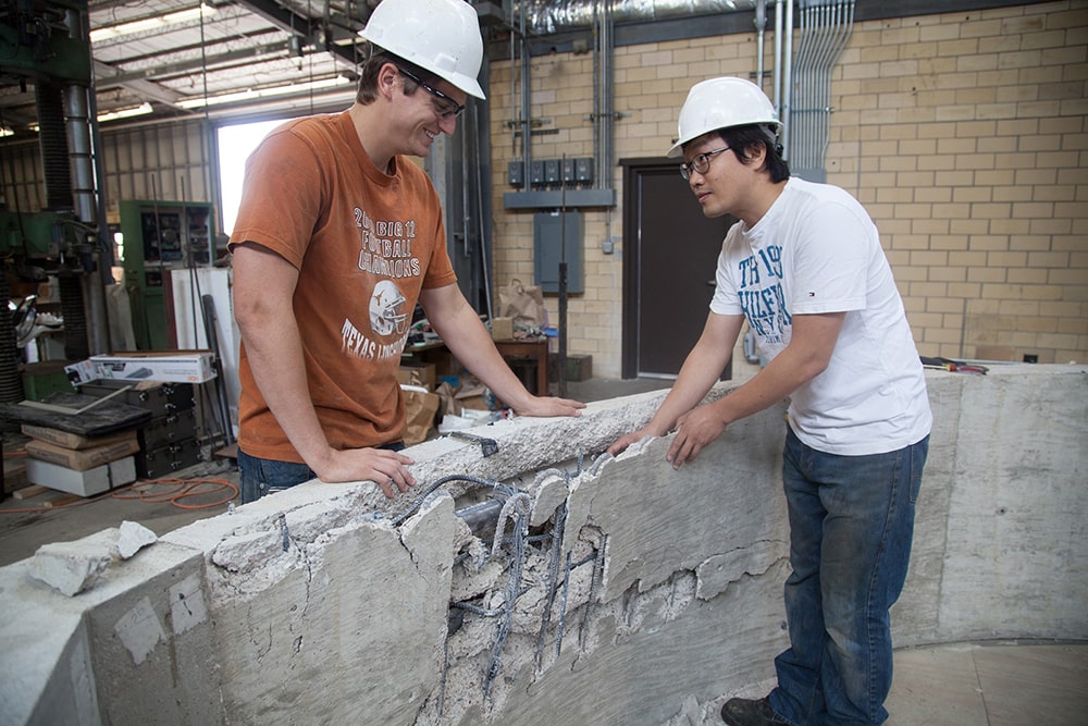 Texas Engineering civil engineering students wearing hardhats talking in building construction zone