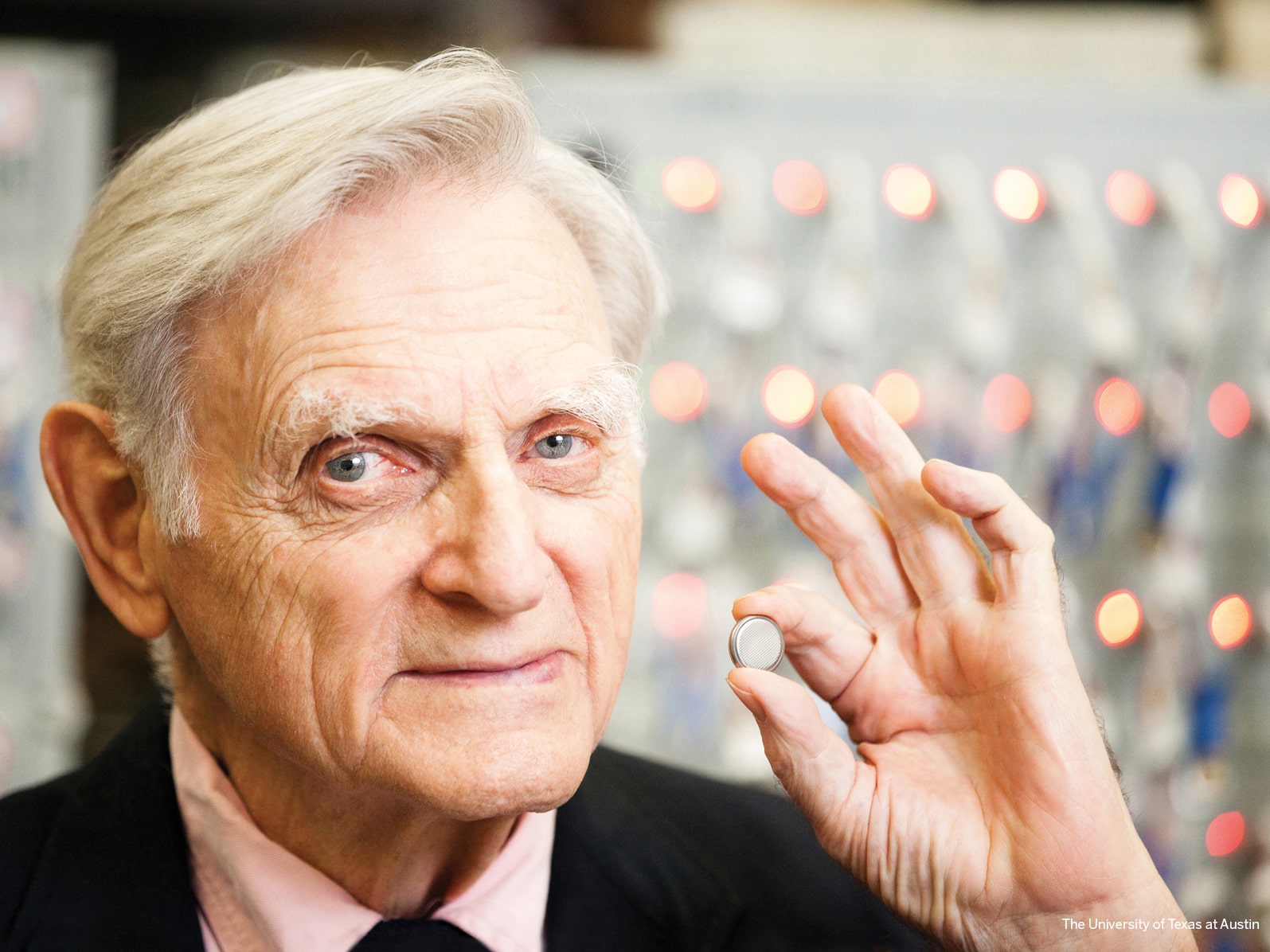 John Goodenough holds lithium ion battery inside of his lab