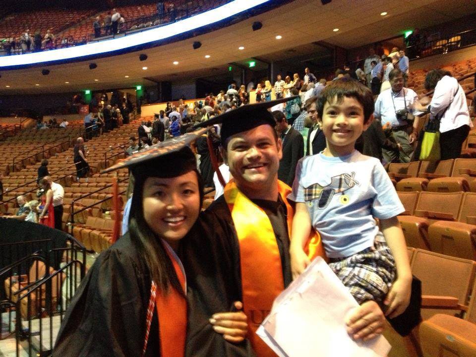 Schaefferkoetter family in graduation regalia holding son