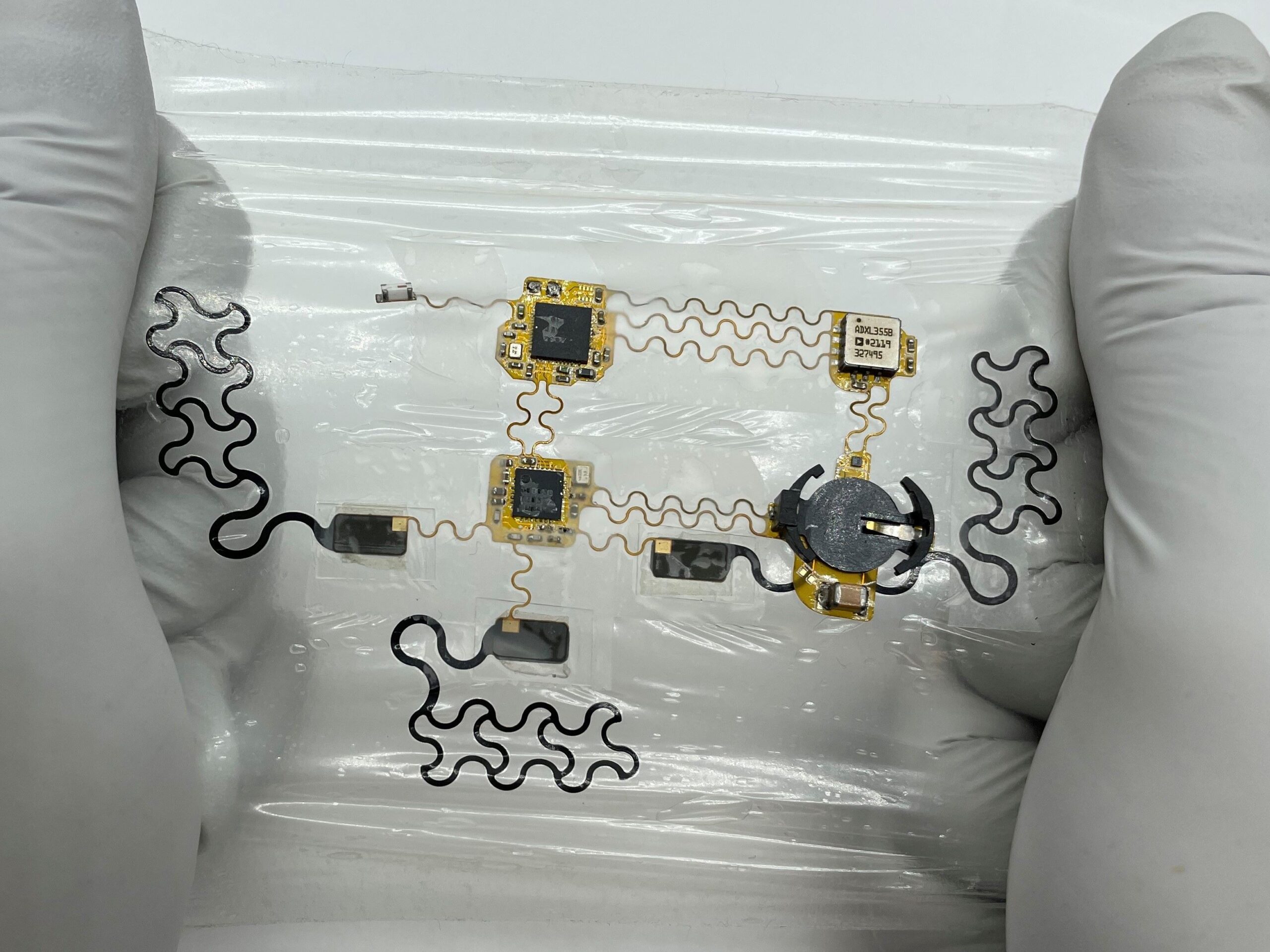 Close up of gloved hands stretching out the e-tattoo prototype