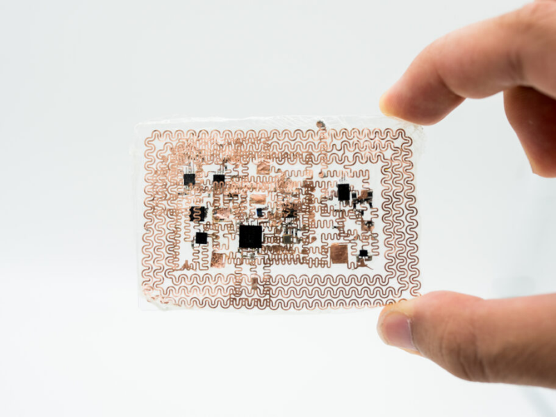 Fingers holding an e-tattoo device