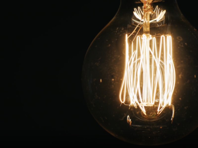 Edison lightbulb lit up in dark room