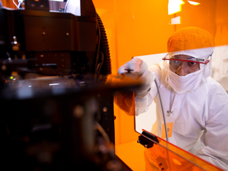 Texas Engineer researcher dressed in lab gear working on machine