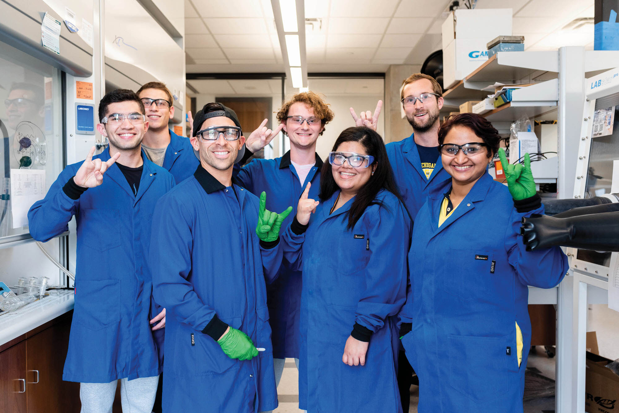 Graduate students in chemical engineering smiling and hook 'ems in Joan Brennecke's lab.