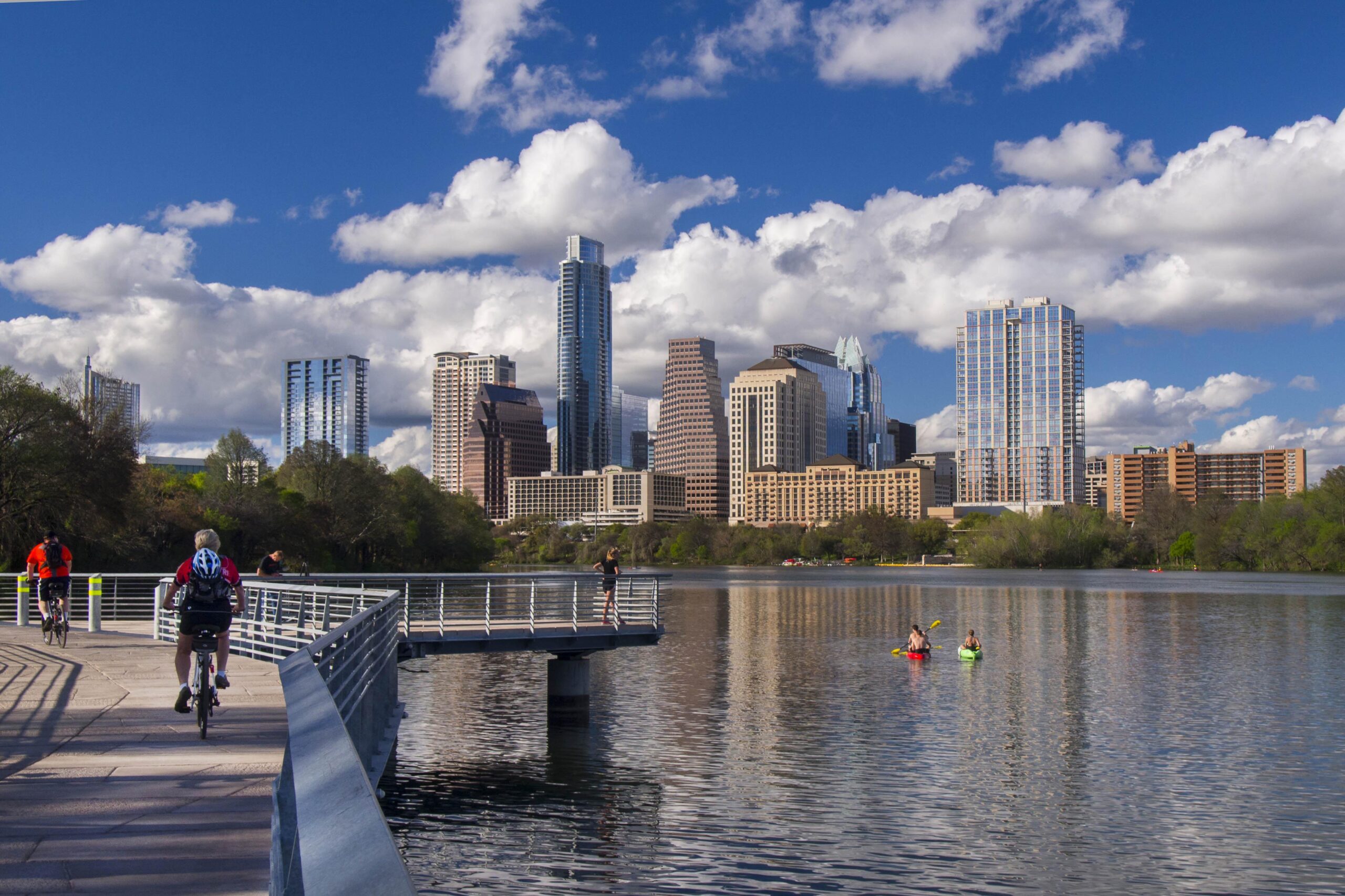 Image of person in kayak on Ladybird Lake in Austin, TX with the city's skyline in the background