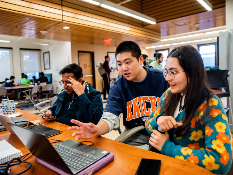 Texas Engineering students gathered around laptops at a Hackathon event