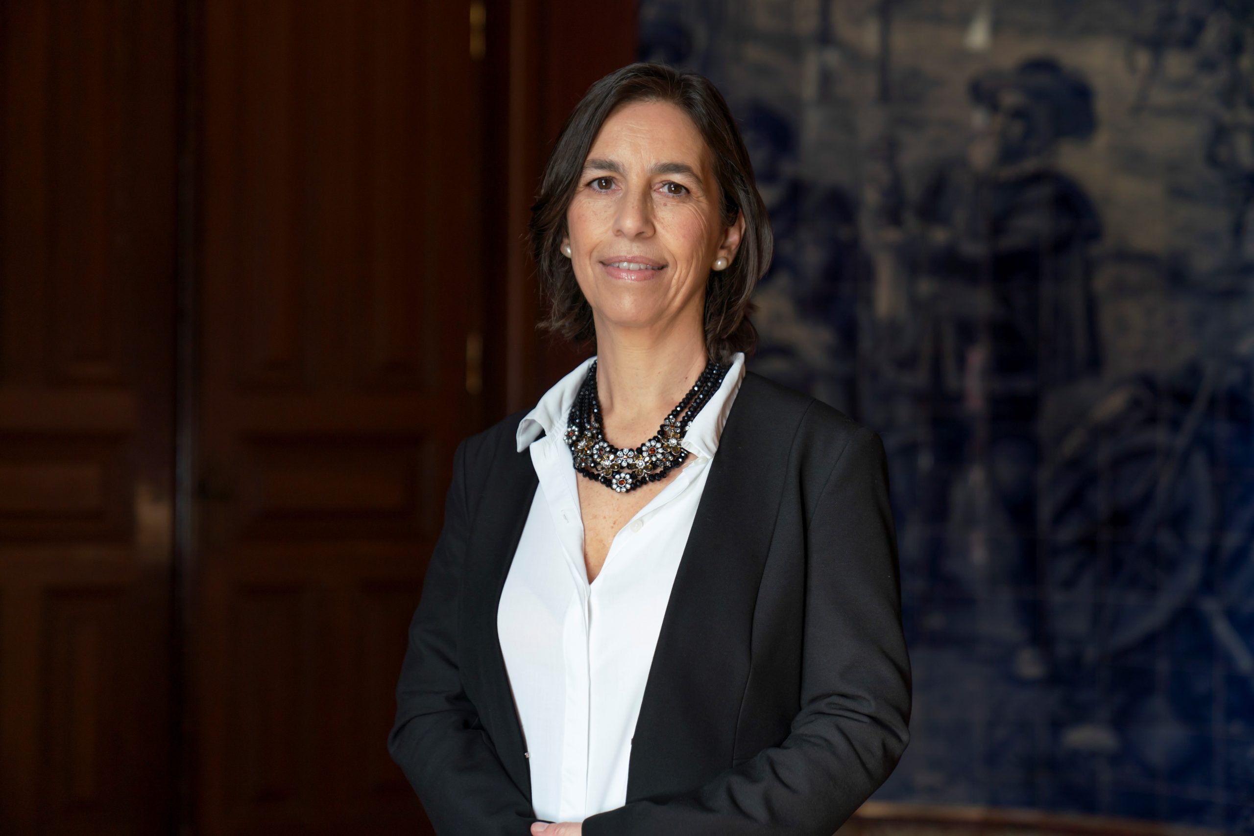 Helena Canhão smiling in front of painting