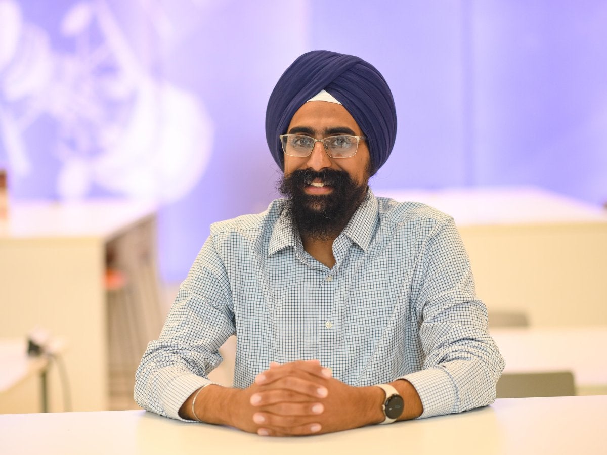 Texas Engineer Puneet Singh smiling with hands folded on table