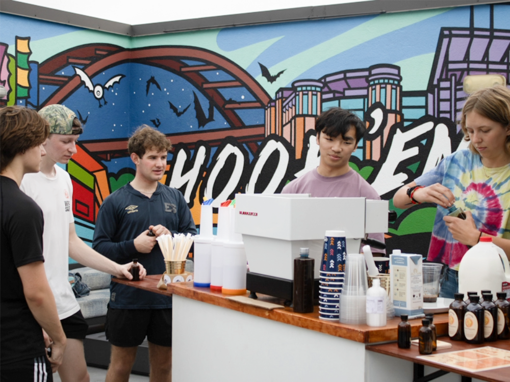 Texas Engineering students talking around a coffee brewing and filling station.