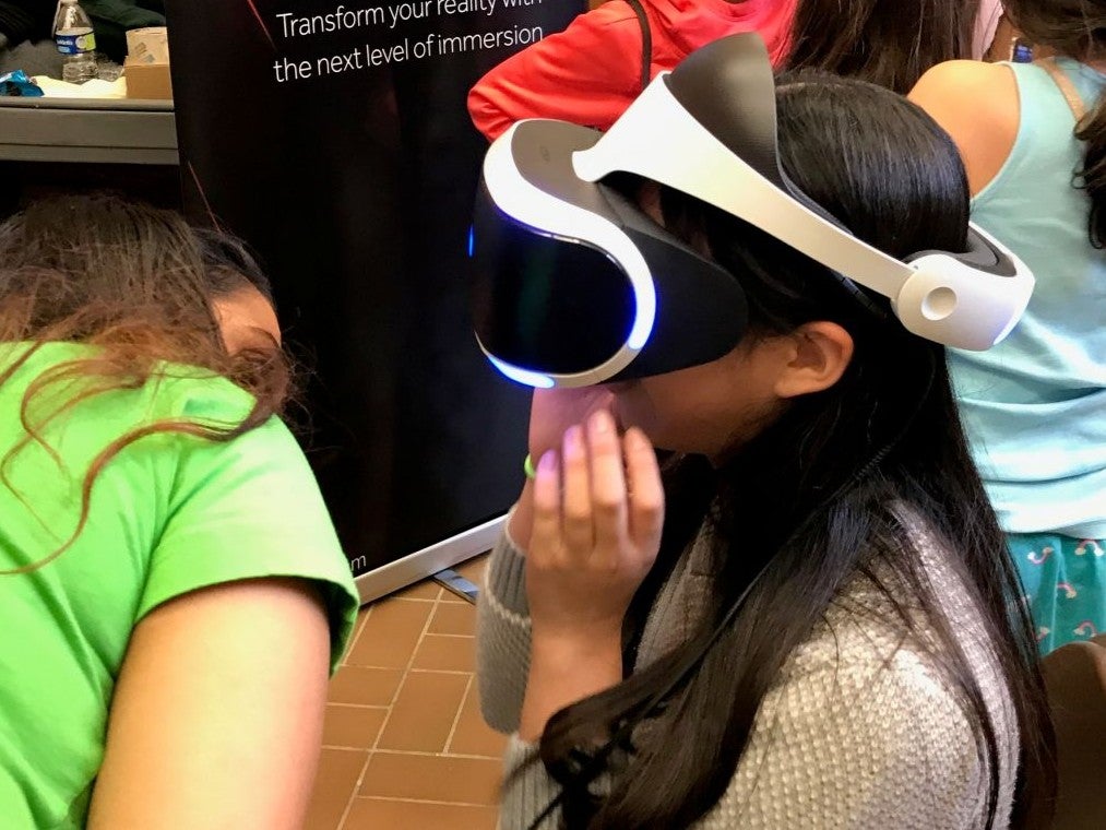 Estella Zhao as a camper at STEM Girl Day, putting on a VR headset.