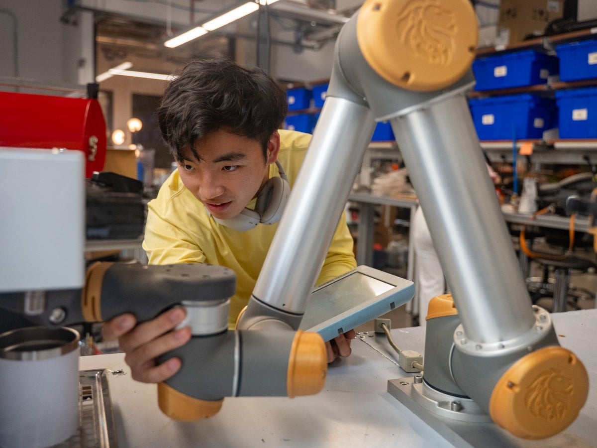 Texas Engineering graduate Jason Wang working on his coffee robot at Texas Inventionworks.