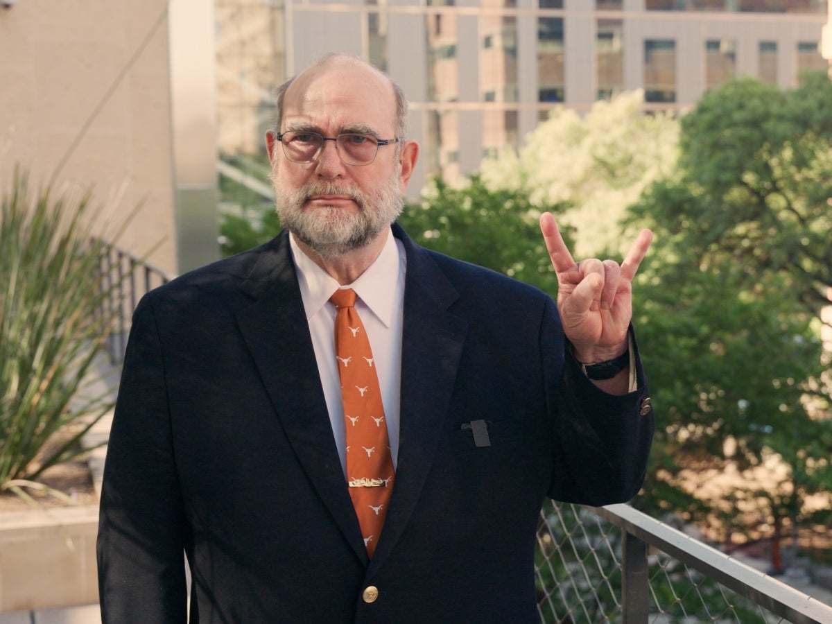 Texas Engineering alumnus Jon McWhirter gives a hook em salute.