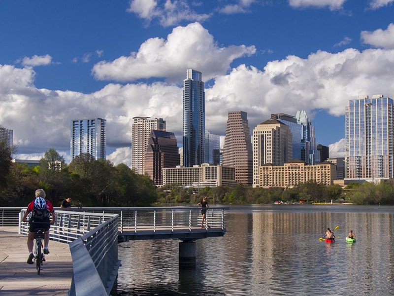 Image of person in kayak on Ladybird Lake in Austin, TX with the city's skyline in the background