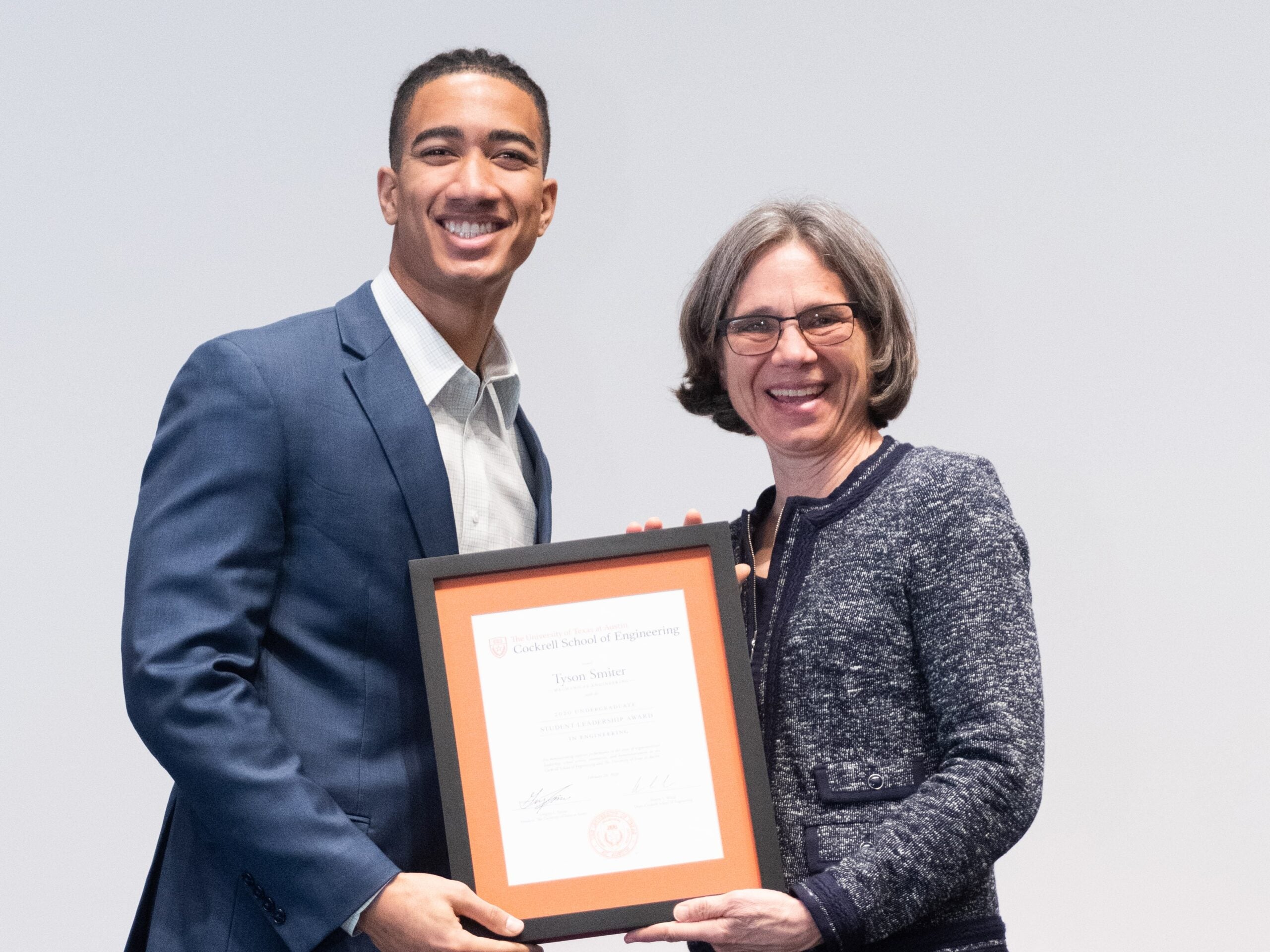 Texas Engineering student Tyson Smiter holding award with Dean Sharon Wood.